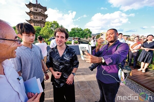 Photo shows a foreign tourist photographing a tourism brochure at the tourist service center in Quanzhou.